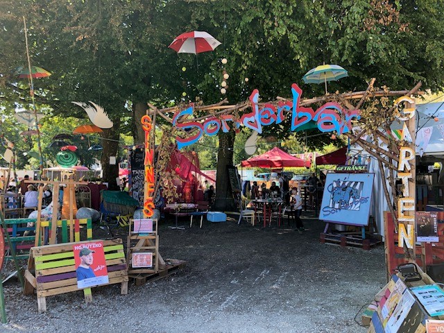 Das bunte Cafè „Sonderbar“ mit Galeriezelt auf dem Musik- und Kultur-Zeltfestival Kult`23 auf der Ludwig-Thoma-Wiese in Dachau.